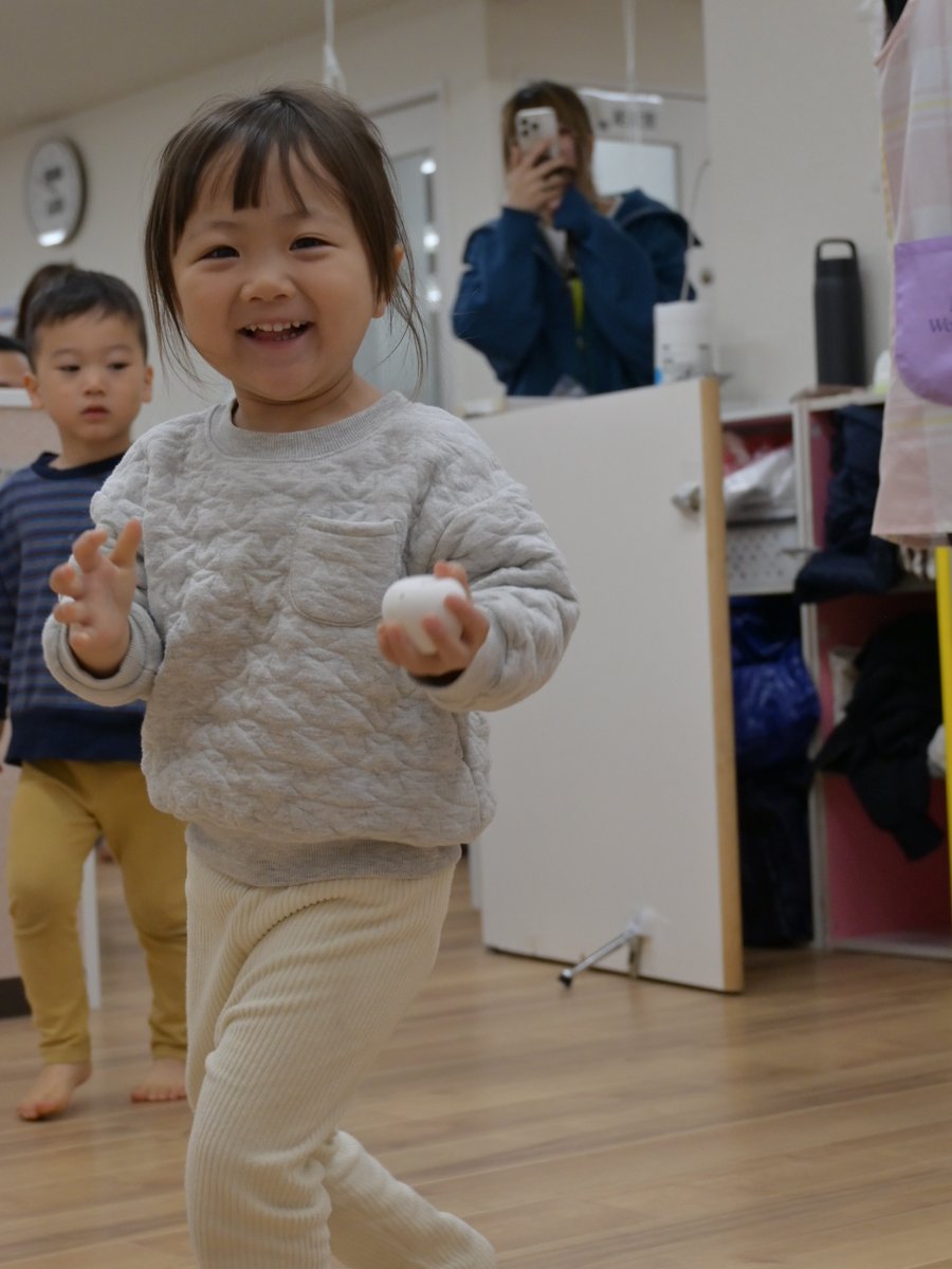 色をつけたりんごを見せる園児