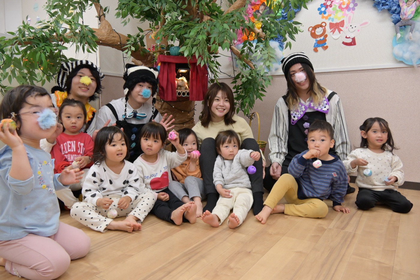 桃花小規模保育園での、メンバーと園児たちの集合写真