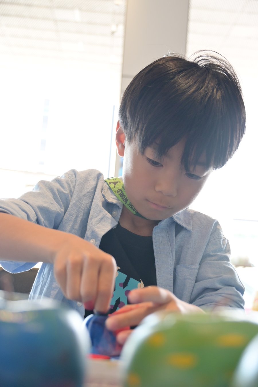 真剣な表情で、自分の手で色をつくる男の子